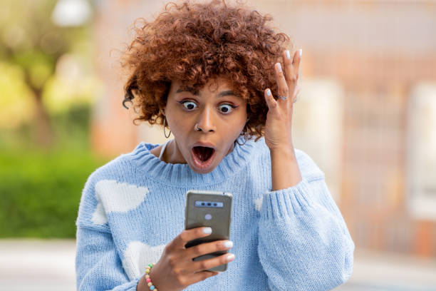 istock surprised girl looking at mobile or cell phone 1442562842