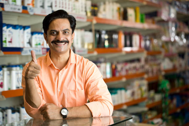 Smiling owner giving thumbs up at checkout in store