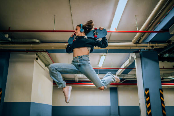 Side view of woman jumping against brick background outdoor.