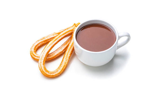 Sweet food: high angle view of two fresh churros with sugar and hot chocolate mug isolated on white background. Dark chocolate bar and pieces complete the composition. High resolution 42Mp studio digital capture taken with Sony A7rII and Sony FE 90mm f2.8 macro G OSS lens
