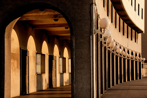 Large street arcade at dusk in A Coruña city, Galicia,  Spain . Columns and shadows in a row.