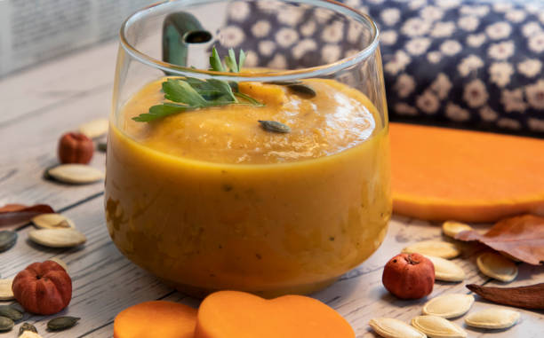 pumpkin and carrot cream soup with seeds and  parsley stock photo