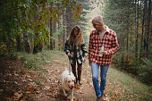 istock Two people enjoy a walk with their dog in the wilderness 1442569621