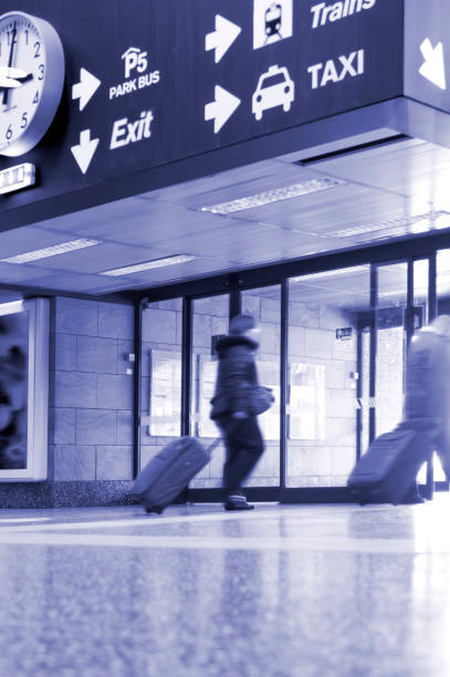 istock airport exit with large clock, signs for parking, train and taxi 1442570735