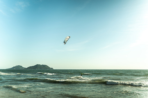 Kite surfer over the pacific ocean in a beach