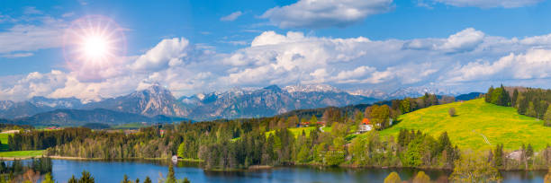 istock panoramic landscape with lake, mountain range and sun on sky 1442574259