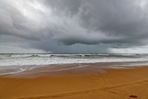 Panjim Goa India - Aug 16, 2022 : Deserted Beach of panjim goa India and thunderstorms approaches the Beach. In the picture tourist taking photo on the beach with family and friends.