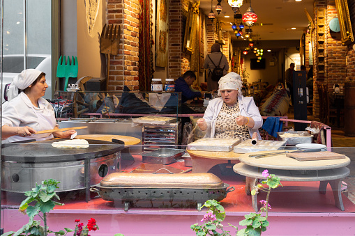 Istanbul, Turkey - May 19, 2022: An elderly women make pancakes in the center of Istanbul