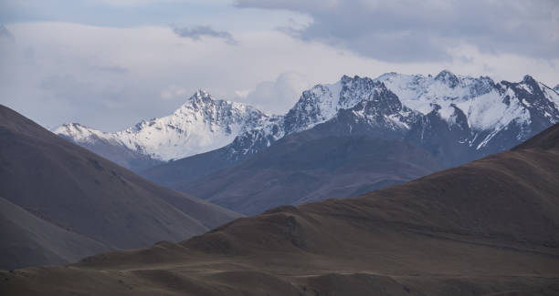 istock Mountain rocky snow-covered range in the mountains with snow in autumn, panoramic view, cloudy day in the mountains 1442577561