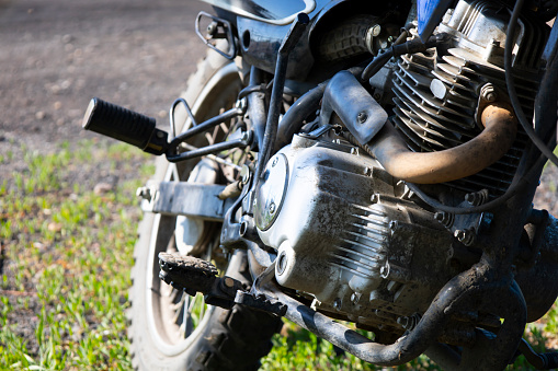 The engine of a subcompact motorcycle is a close-up parked on a green lawn. High quality photo