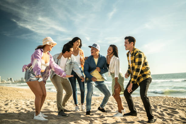 Friends having fun and dancing at the beach
