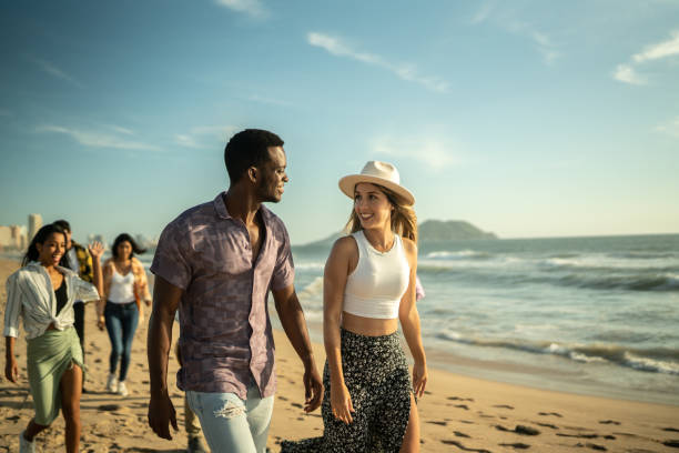 istock Young friends walking along the beach 1442580106