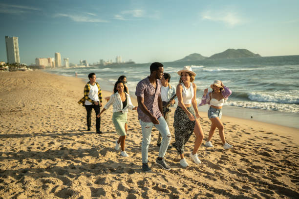 istock Young friends walking along the beach 1442580136