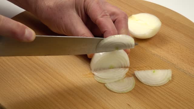 Cutting a white onion into slices