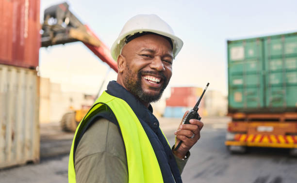 istock Logistics, communication and black man talking on walkie talkie while working at a storage port with container. Portrait of an African manufacturing manager speaking on tech while shipping cargo 1442582573