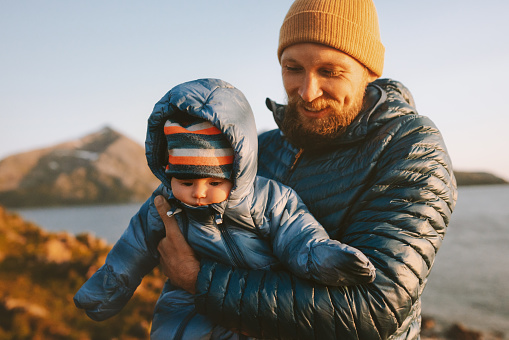 Father walking with baby outdoor family lifestyle travel together man with infant child wearing winter clothing