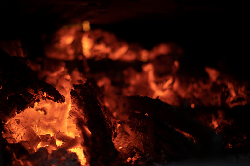 Burning of firewood in hearth. Flames of pyre. Texture of fire inside furnace. Combustion process.