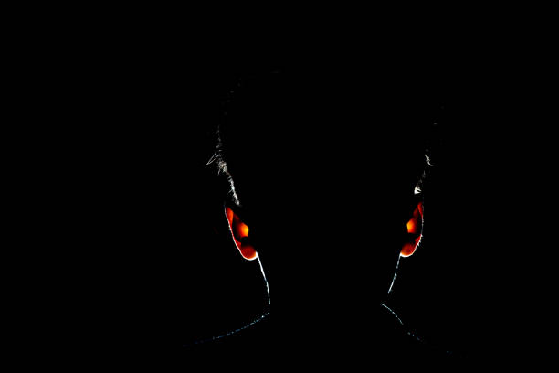 Unrecognizable young dark young male silhouette isolated in shadow, studio portrait.