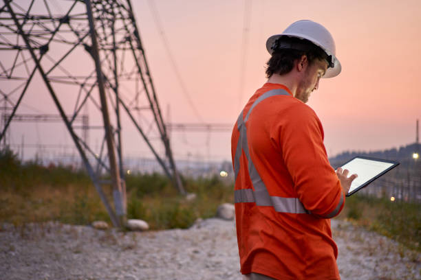 istock Electrical engineer working on a tablet by pylons at dusk 1442587175