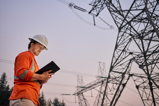 Power Line Engineer Electrical Engineer Using A Tablet By Power Lines At Dusk Stock Photo ...