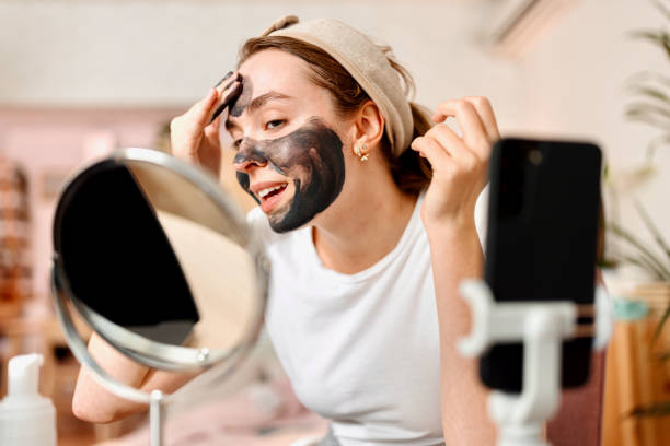 wanita mengaplikasikan masker pembersih wajah arang hitam. - charcoal mask potret stok, foto, & gambar bebas royalti