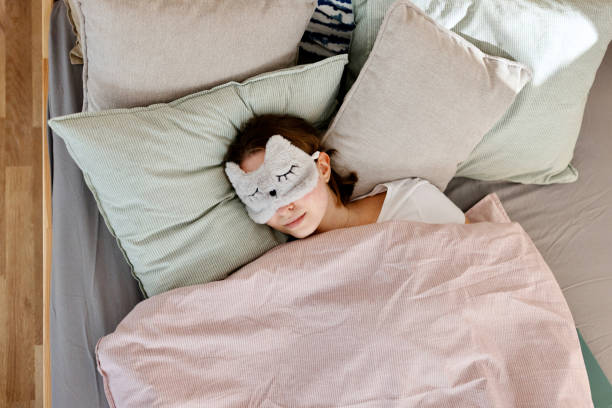 istock Young woman sleeping with a mask on in bed 1442590524