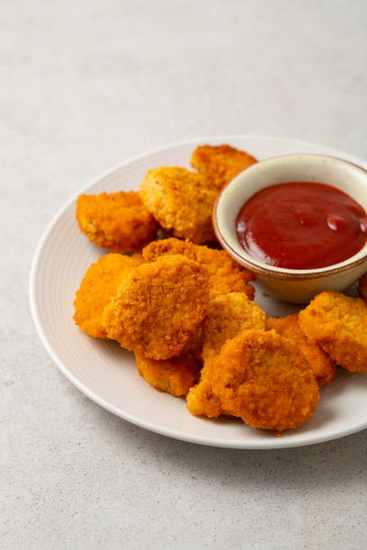 istock Close up of chicken nuggets and dip on light surface 1442590711
