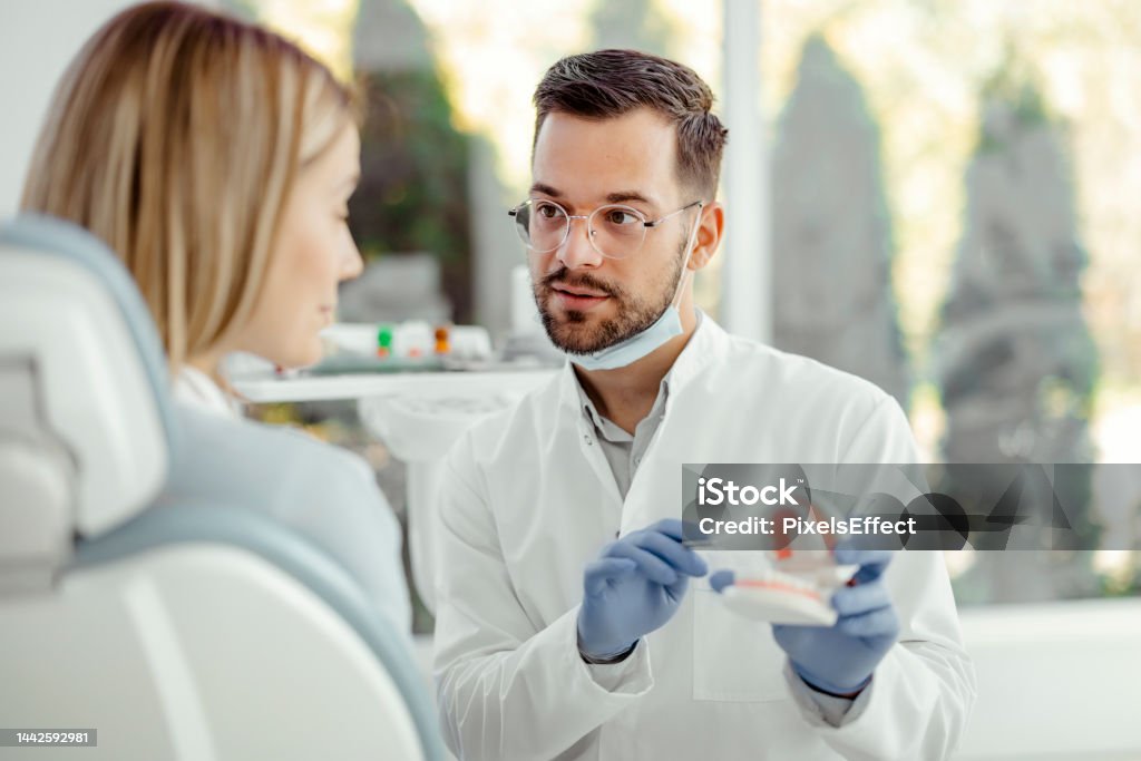 Dentists discussing Dental Problems with Patient Dentists are discussing dental problems with female patient Dentist Stock Photo