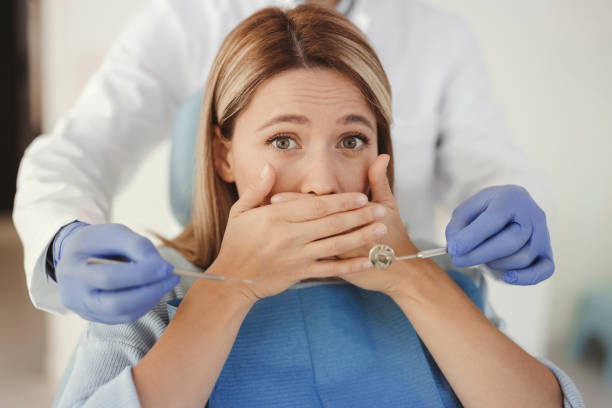 Woman at Dental Practice Refusing Dentist Treatment stock photo
