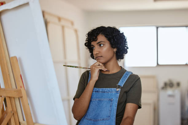 istock Paint, art and idea with a woman thinking about an artistic project in her design studio for creative expression. Painter, artistic and creativity with a painter doubt or confused in a workshop 1442595544