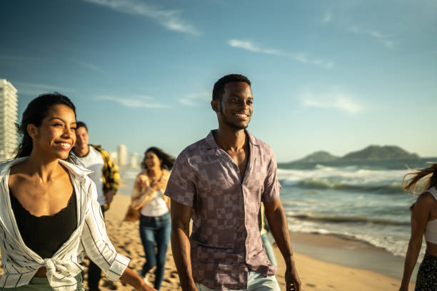 istock Young friends walking along the beach 1442600531