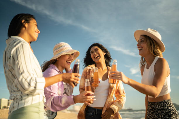 Friends drinking and talking at the beach