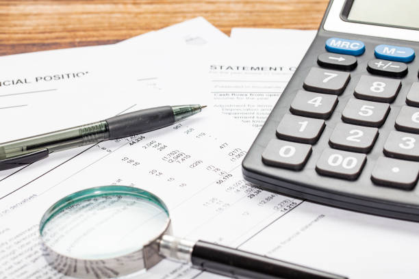 cash flow statement with calculator cash flow statement with calculator, pen and hand glass financial statement stock pictures, royalty-free photos & images