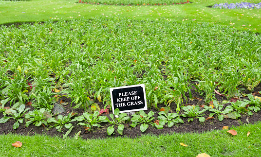 Please keep off the grass sign in a community garden