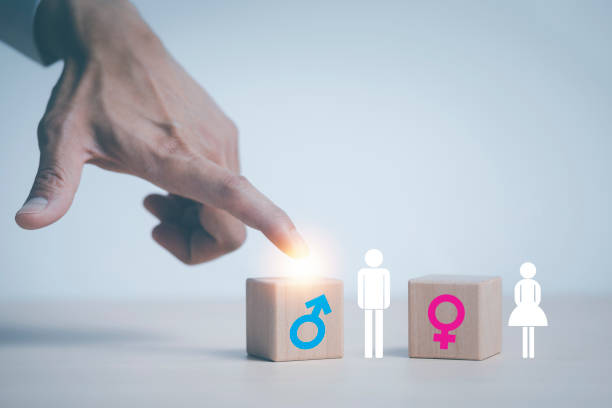 concept equality and differences between men and women, Hand touch wooden cube with male icon on top of cubes, gender discrimination in employment. Wooden blocks with male and female symbols. stock photo