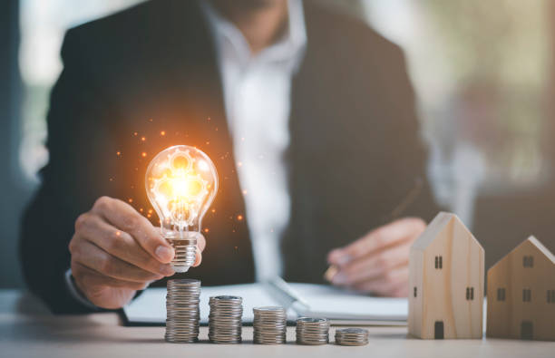 istock Businessman hand holding light bulb with line connect and Coins stack on the wooden table, Saving ideas and investment budget, Creative ideas concept of saving money  concept, Copy space 1442610529