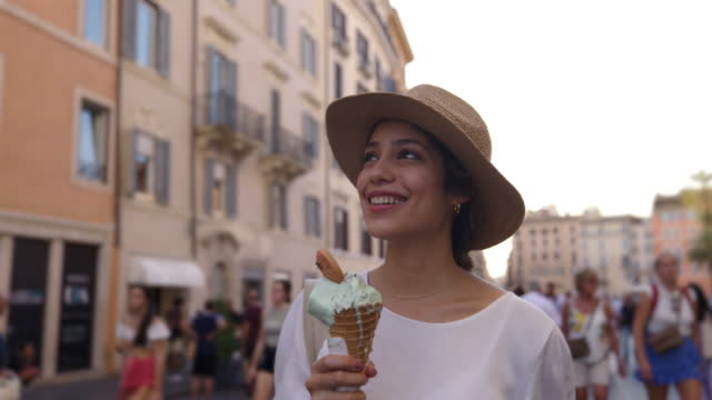 Beautiful woman sightseeing in Rome while enjoying a delicious gelato