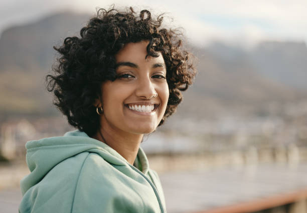 portrait, face and indian woman on a rooftop, relax and happy while enjoying sunrise and city views. freedom, peaceful and wellness girl meditating, start day with positive mindset and relaxation - silence curly hair facial expression female imagens e fotografias de stock