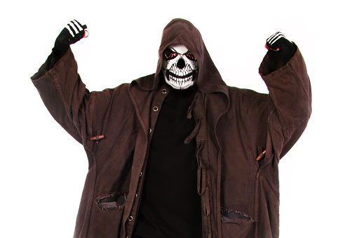 Vertical photo of the Grim Reaper (skelton, demon, monster) with his arms raised showing power, standing against a white background, and wearing a long hooded duster coat.