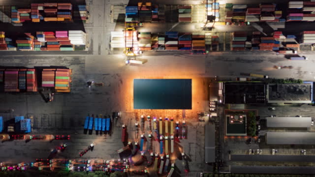 4K Time lapse or Hyper lapse : Container trucks line up to enter the terminal for unload container to container cargo ship at terminal commercial port, Business logistics import export or freight transportation.