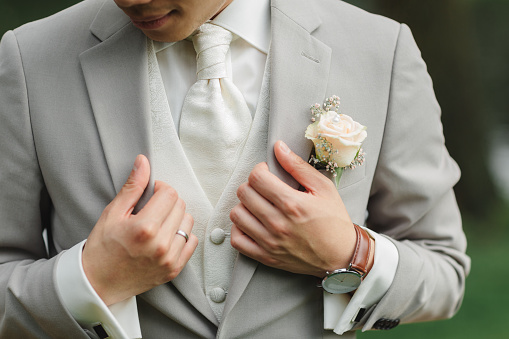 Boutonniere on the groom's jacket. Flower on a man's jacket. a man in a jacket with a flower