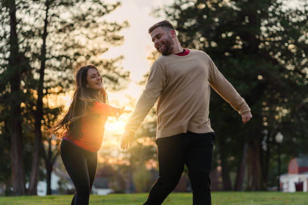 istock romantic couple in the park with sunset 1442626396