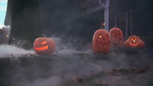 Smoke comes out of halloween pumpkins near the house