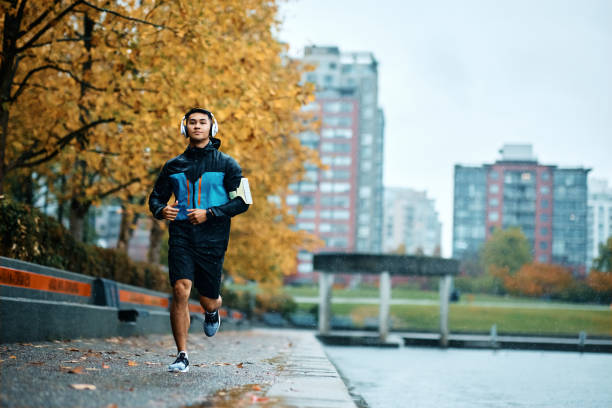 istock Motivated athletic man running outdoors during bad weather. 1442635332