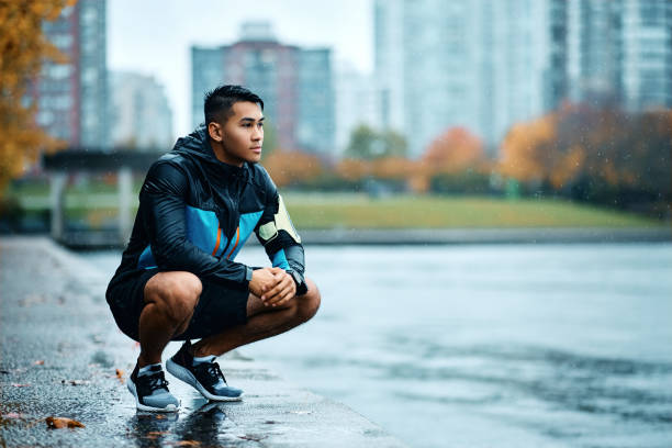 istock Young sportsman taking a break while exercising outdoors on bad weather. 1442635434