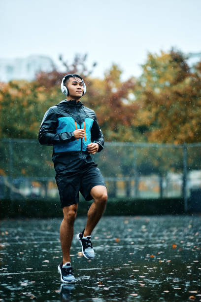 istock Young athlete running in place while exercising outdoors during bad weather. 1442636107