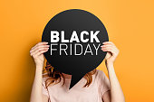 woman holding blank speech balloon with black friday isolated on an orange background