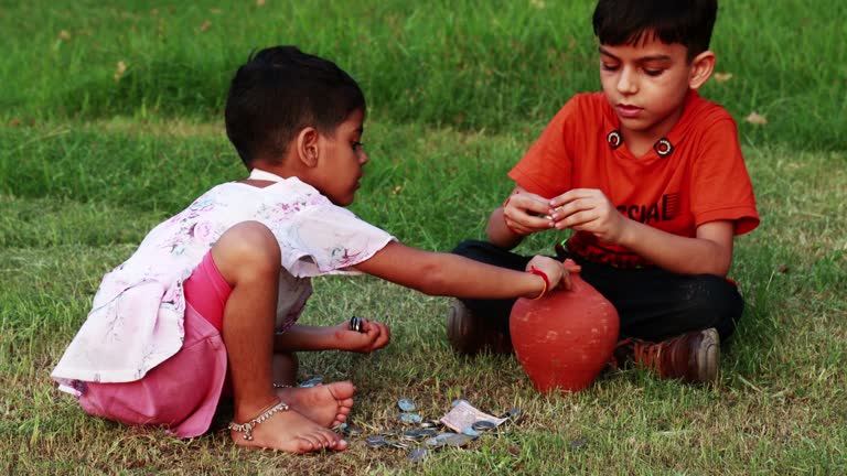 Elementary child saving money in piggy bank