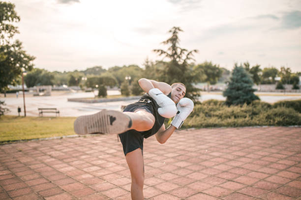 istock Confident kickboxer practicing high kick in the public park 1442647296