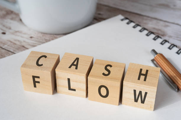 holzklötze mit "cash flow"-konzepttext, einem stift, einem notizbuch und einer tasse. - geldfluss stock-fotos und bilder